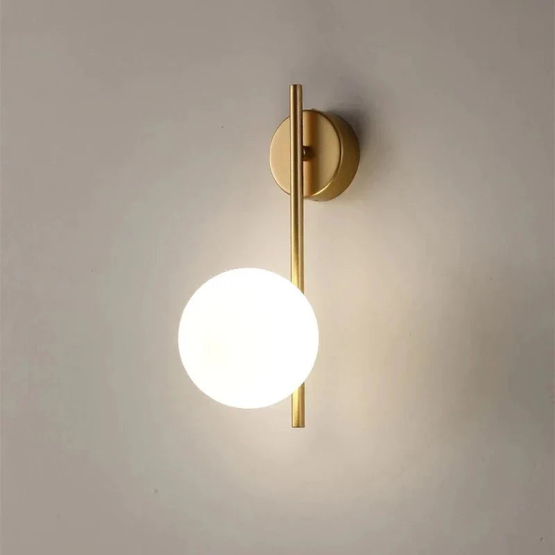 Australum LUNA gold globe sconce installed in bedroom