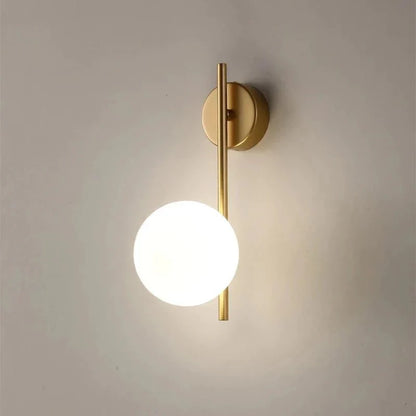 Australum LUNA gold globe sconce installed in bedroom